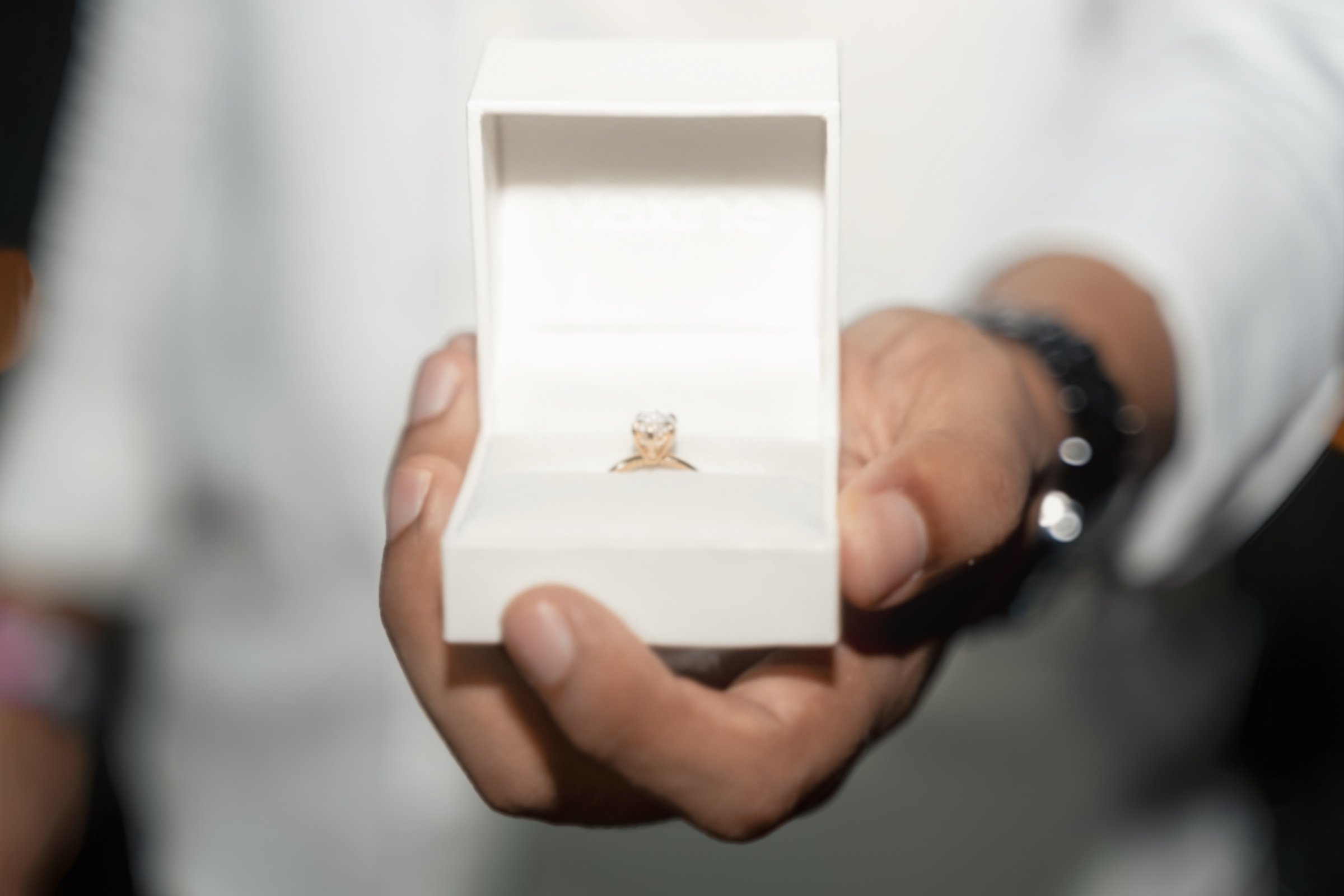 El anillo de compromiso dentro de su caja blanca abierta.